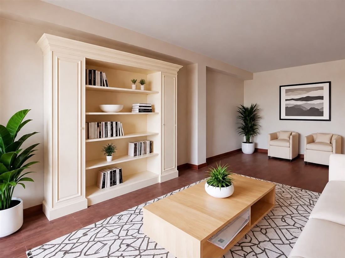 Salón preparado con home staging: librería a medida, mesa de centro de madera, plantas y butacas
